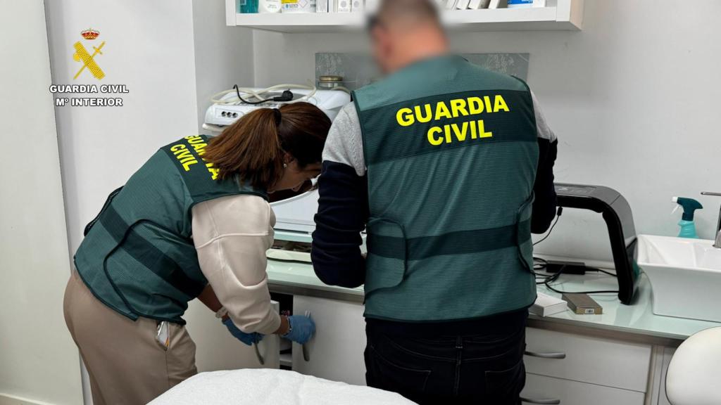 Dos agentes de la Guardia Civil revisan las muestras intervenidas en una clínica clandestina