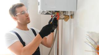 Instalador trabajando en un cambio del gas verde para las calderas en una vivienda