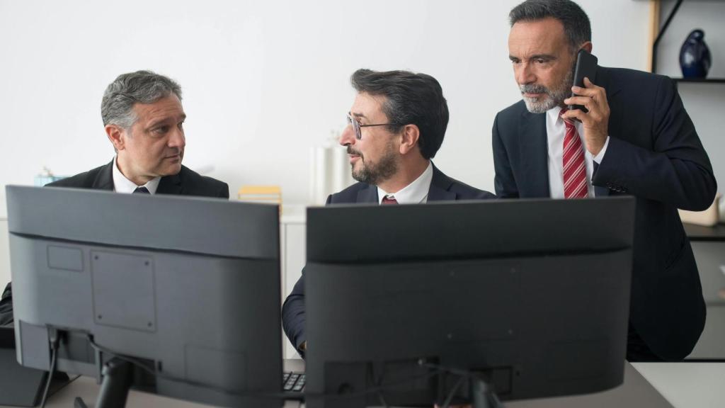 Hombres de negocios revisan transacciones comerciales frente al ordenador
