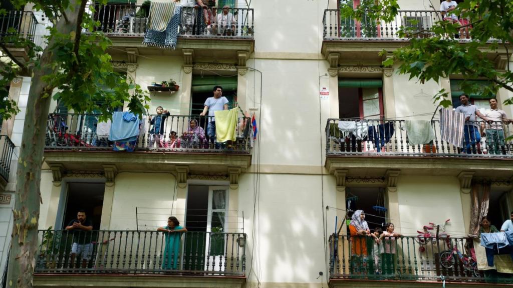 Residentes del Raval en el balcón antes del paso del papa León XIV por el barrio