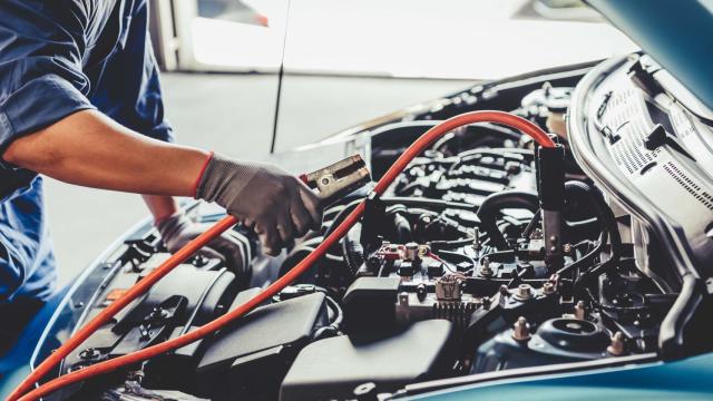 Un operario repara un coche en un taller / EP