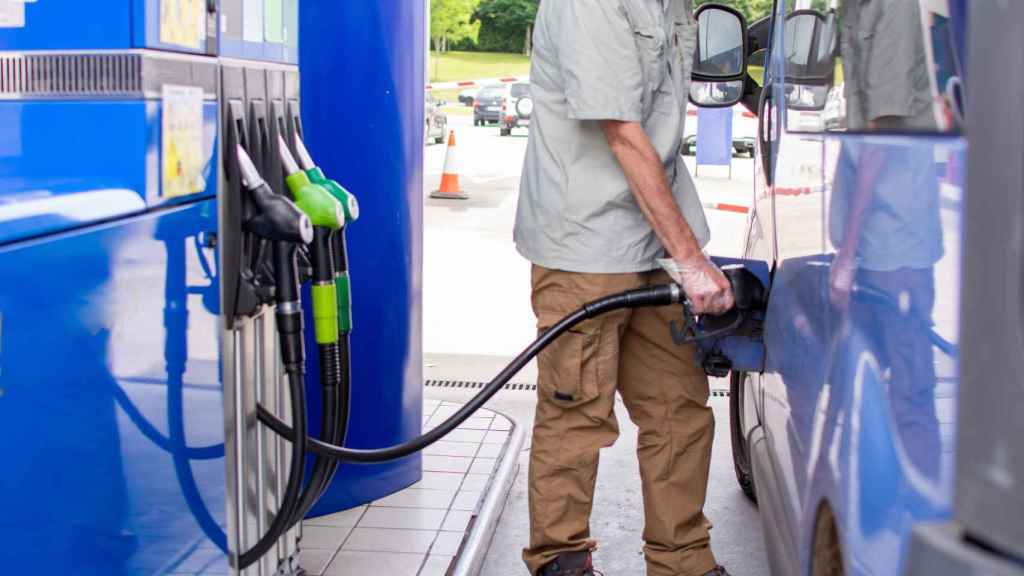 Un hombre reposta en una estación de servicio.