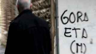Un hombre pasa junto a una pintada a favor de ETA.