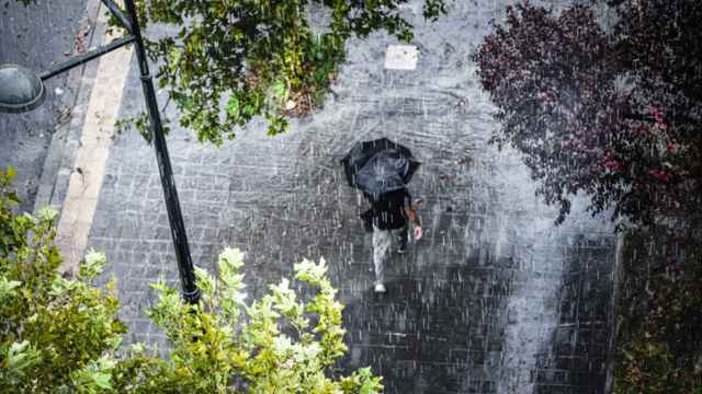 Un hombre camina bajo la lluvia.