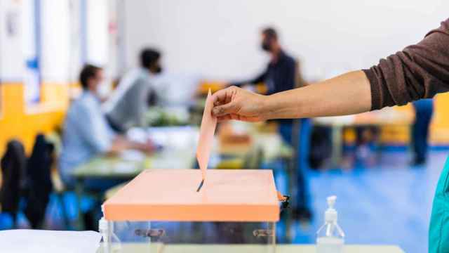 Un hombre deposita su voto en una urna.