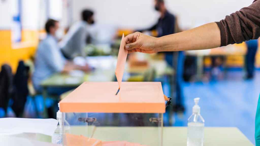 Un hombre deposita su voto en una urna.