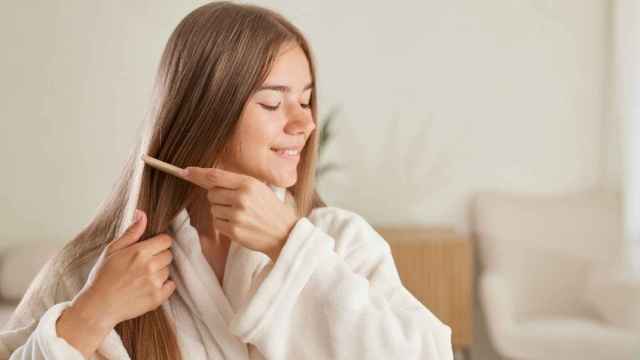Una mujer se cepilla la melena tras lavarse el pelo