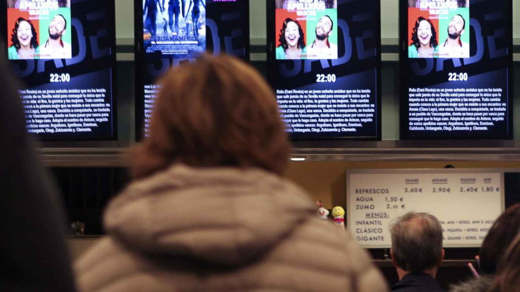 Una señora mira la cartelera de un cine en una imagen de archivo