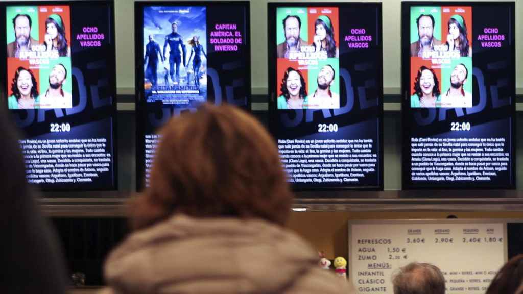 Una señora mira la cartelera de un cine en una imagen de archivo