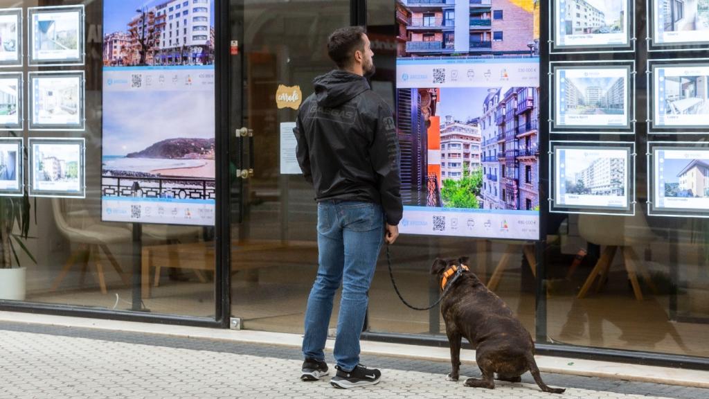Un joven mira los anuncios de una inmobiliaria