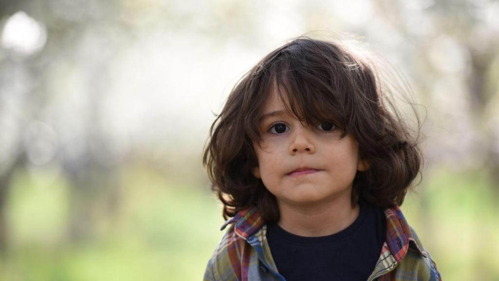 Un niño mira a cámara.