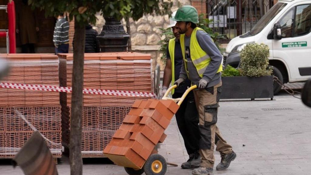 Un trabajador carga con peso en una foto de archivo