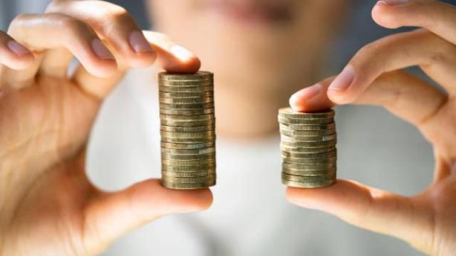 Un hombre realiza una comparación de dinero con monedas.