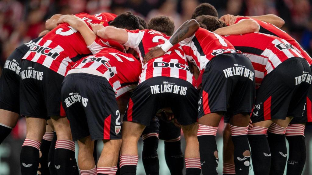 Los jugadores del Athletic Club se reúnen antes del inicio del encuentro, con el sponsor en primer plano.