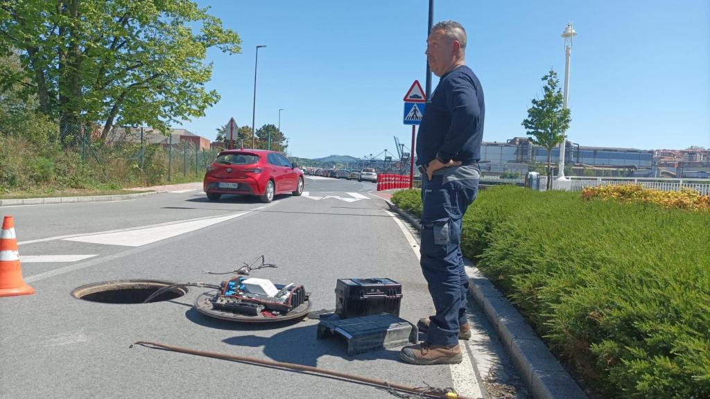 Un operario trata de restablecer el servicio de Internet en Leioa con ArcelorMittal Sestao al fondo