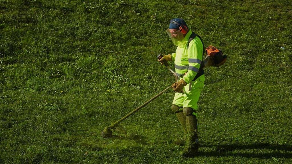 Un trabajador de Enviser trabaja en el mantenimiento de un jardín