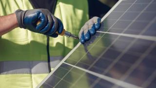 Imagen de archivo de un trabajador manipulando una placa solar