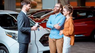 Clientes preguntando por un coche eléctrico en el concesionario