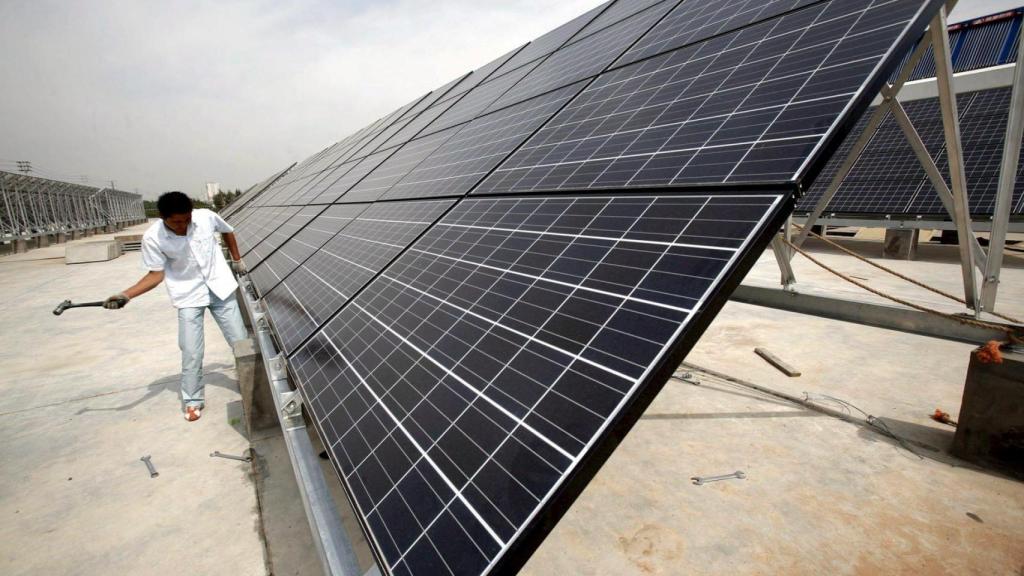 Un trabajador trabaja en una placa fotovoltaica