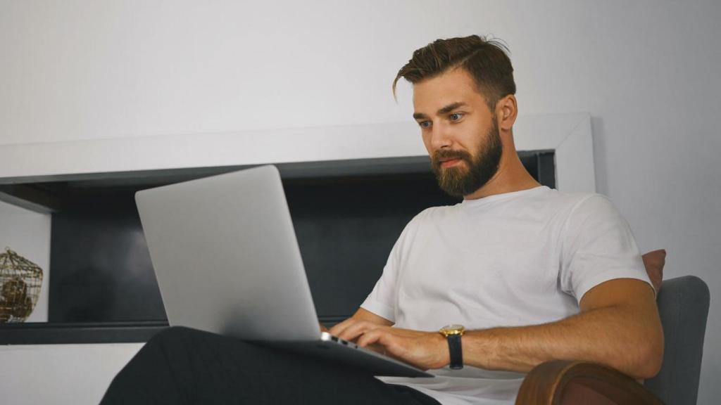 Hombre sentado con un ordenador portátil