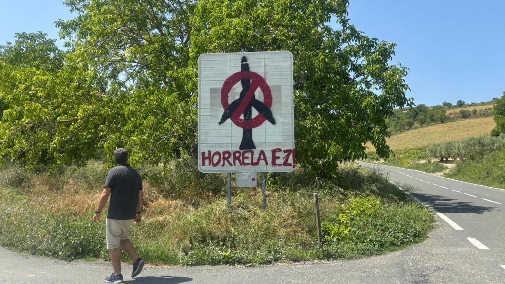 Una persona observa un cartel contra el parque eólico de Labraza