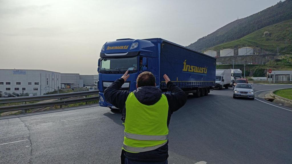 Un miembro de la Plataforma frente a un camionero que va a acceder al Puerto de Bilbao
