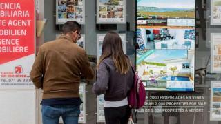 Personas en el escaparate de inmobiliaria / imagen de archivo