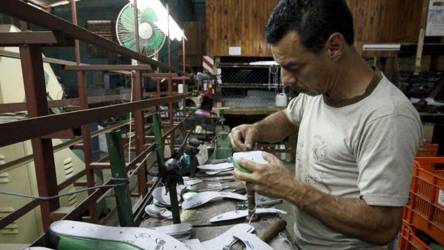 Un zapatero realiza labores de arreglo de zapatos