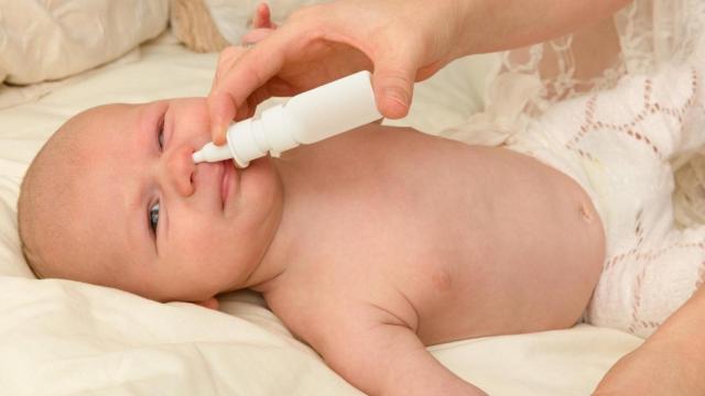 Una madre aplica un nebulizador para diluir la mucosidad del bebé / QUIRÓNSALUD