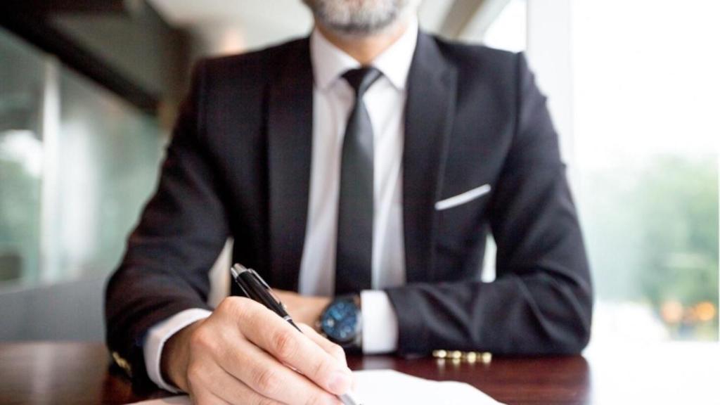 Abogado con un bolígrafo sentado a una mesa