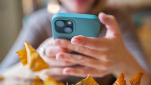 Una mujer mira su teléfono móvil