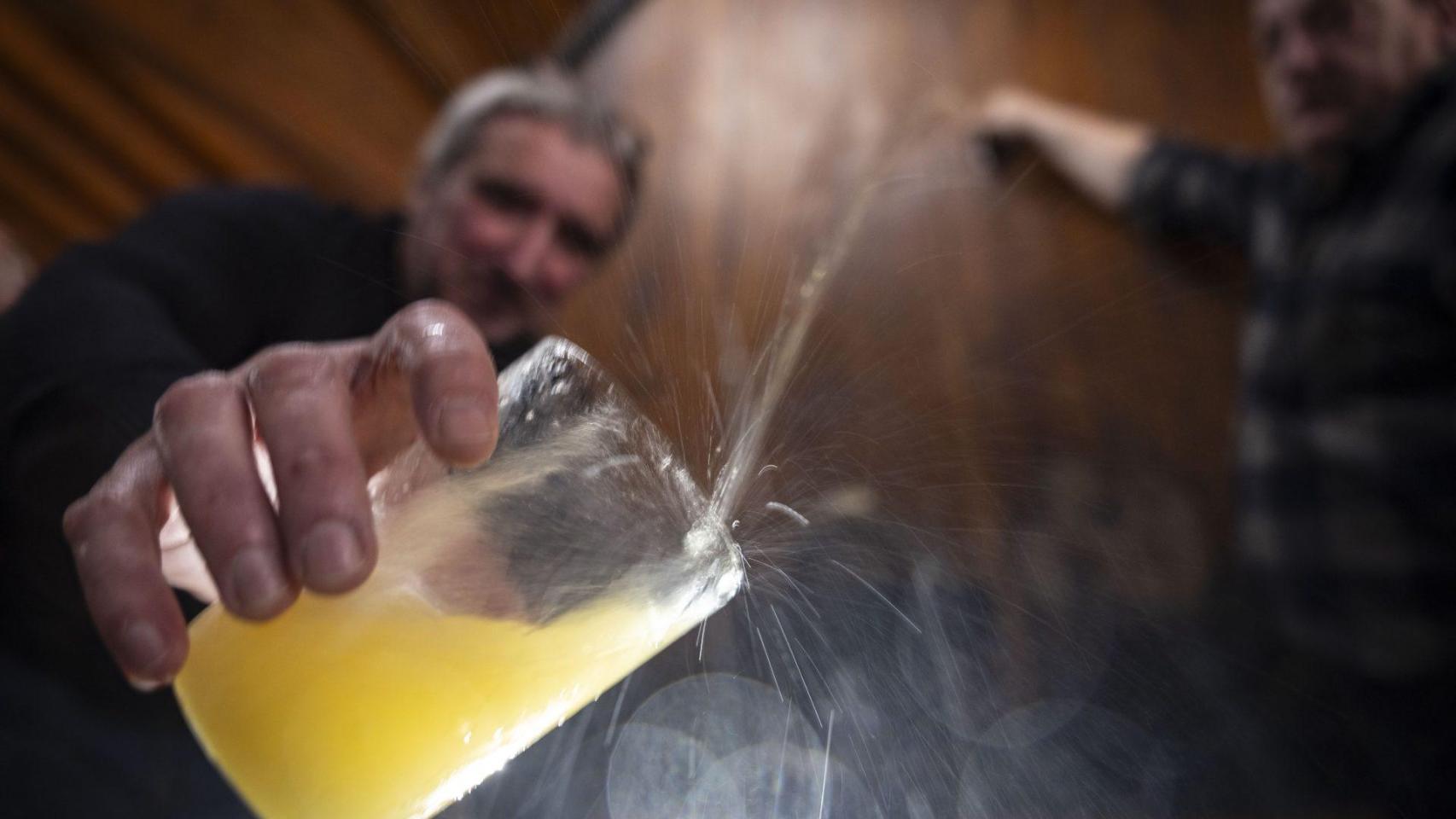 Un invitado recoge en su vaso la sidra escanciada de la kupela