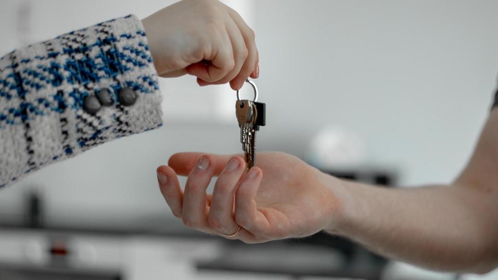 Una propietaria de un piso entrega sus llaves a la inquilina.