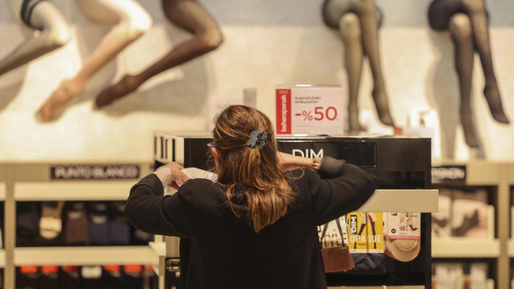 Una dependienta coloca el cartel de rebajas en un centro comercial este miércoles en Bilbao