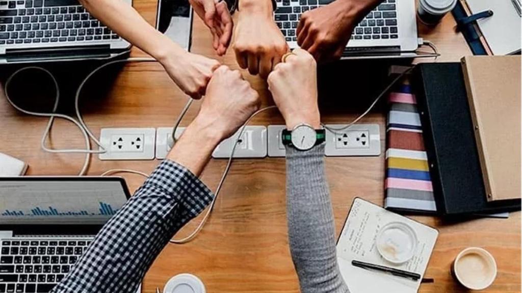 Puños unidos de un equipo de trabajo en una oficina