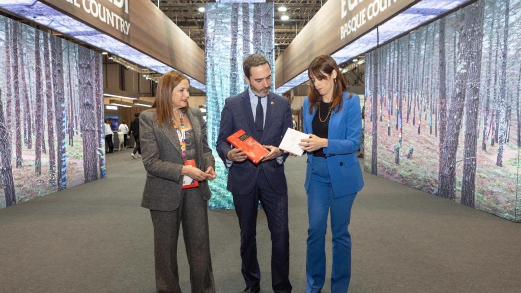 María Jesús San José, Javier Hurtado y Maider Etxebarria posan con el libro sobre el 3 de marzo que han entregado a los reyes en Fitur.