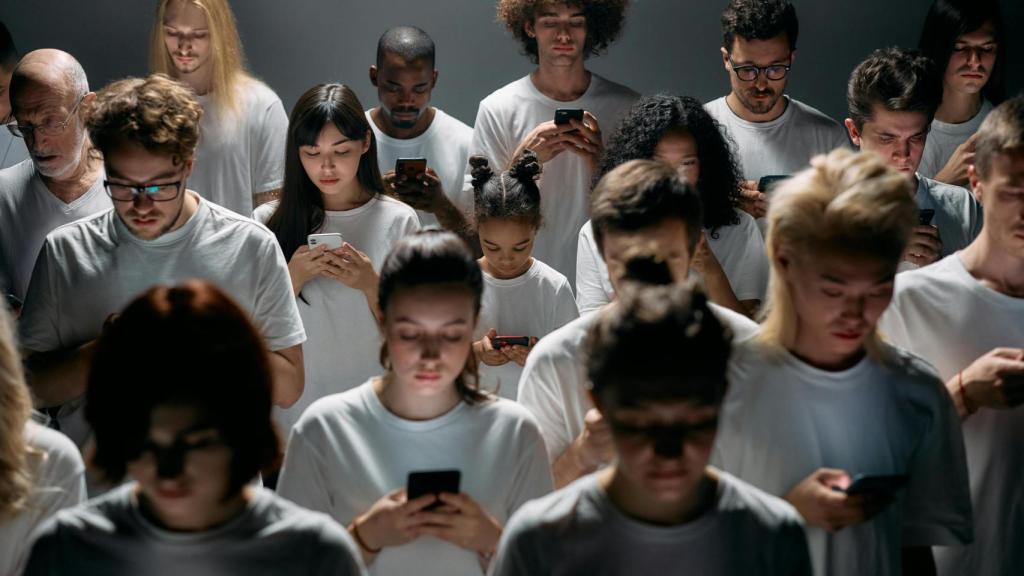 Una multitud de niños y adolescentes haciendo uso de su teléfono inteligente