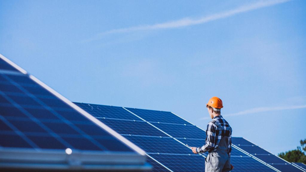 Trabajador, durante una jornada laboral junto a paneles solares.