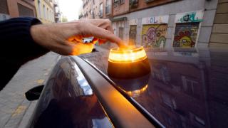 Imagen de una persona colocando una de las balizas V16 en su coche.