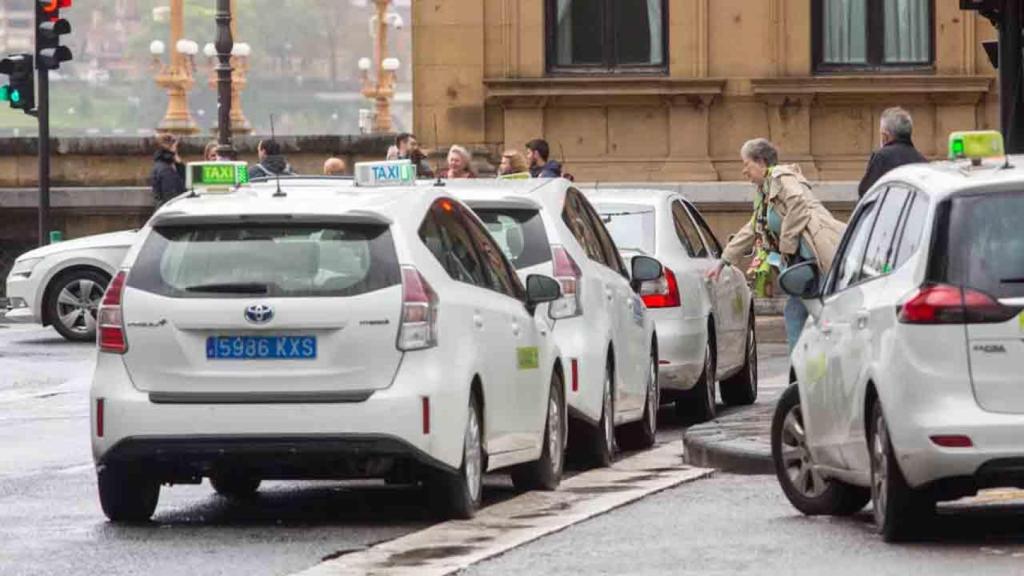 Una mujer coge un taxi frente al Ayuntamiento de Donostia.