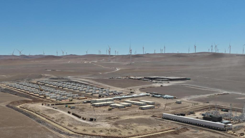 Un proyecto híbrido de GES en Chile en el que se observa la instalación BESS y la subestación eléctrica con un parque eólico al fondo