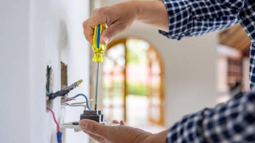 Un vecino realizando una instalación eléctrica.