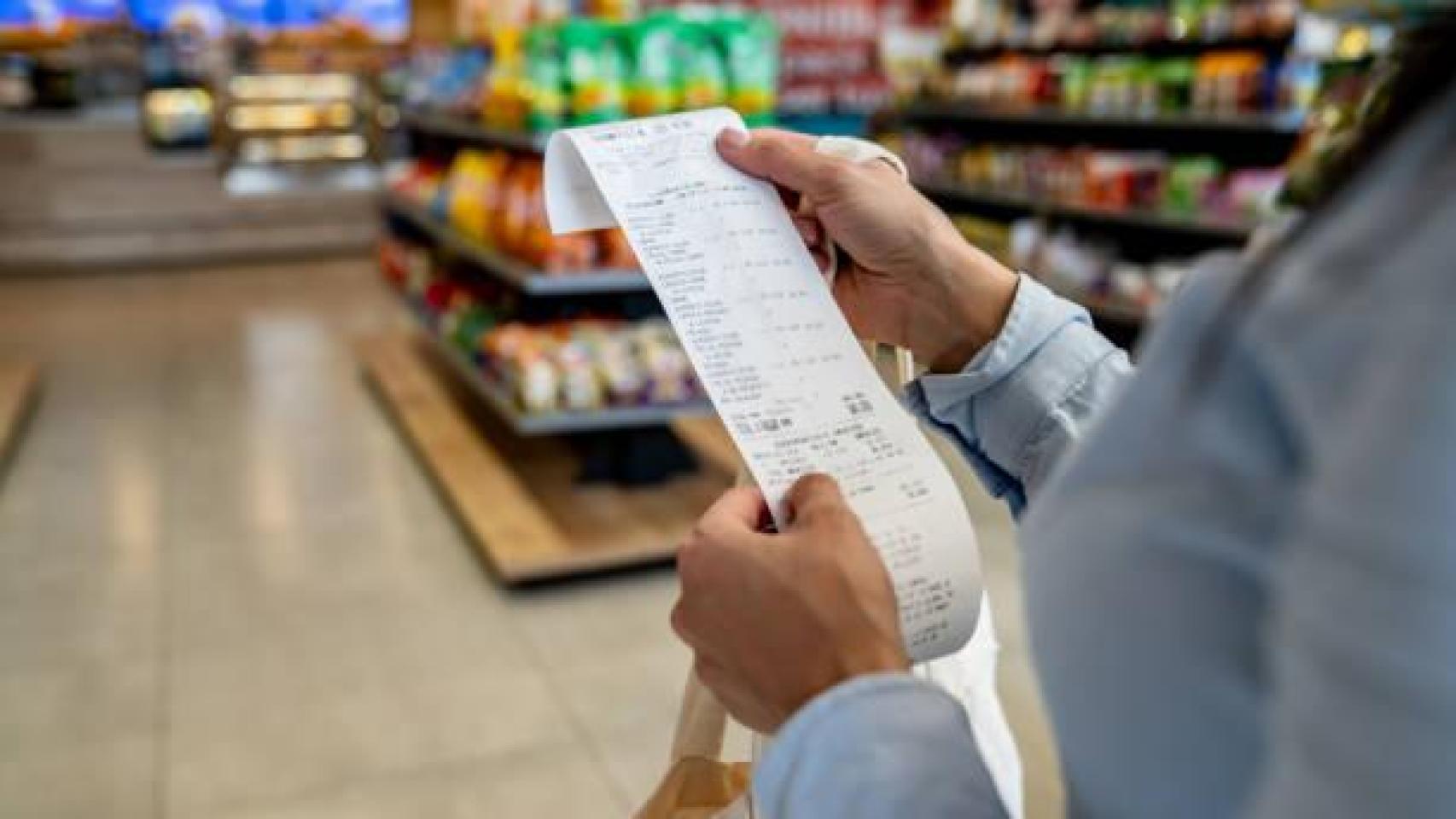 Una mujer revisa el ticket de la compra.