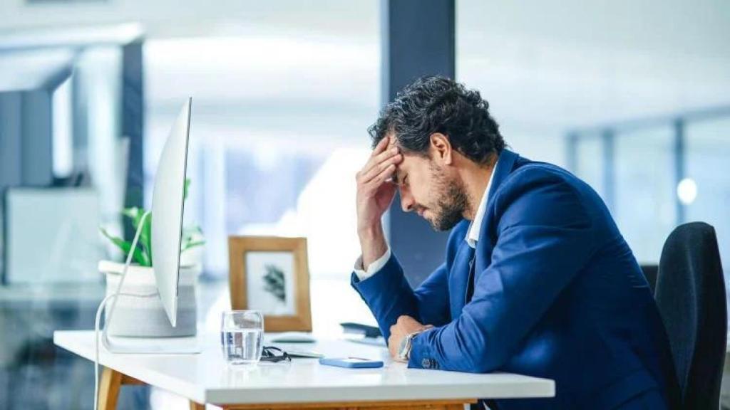 Un hombre saturado en el trabajo.