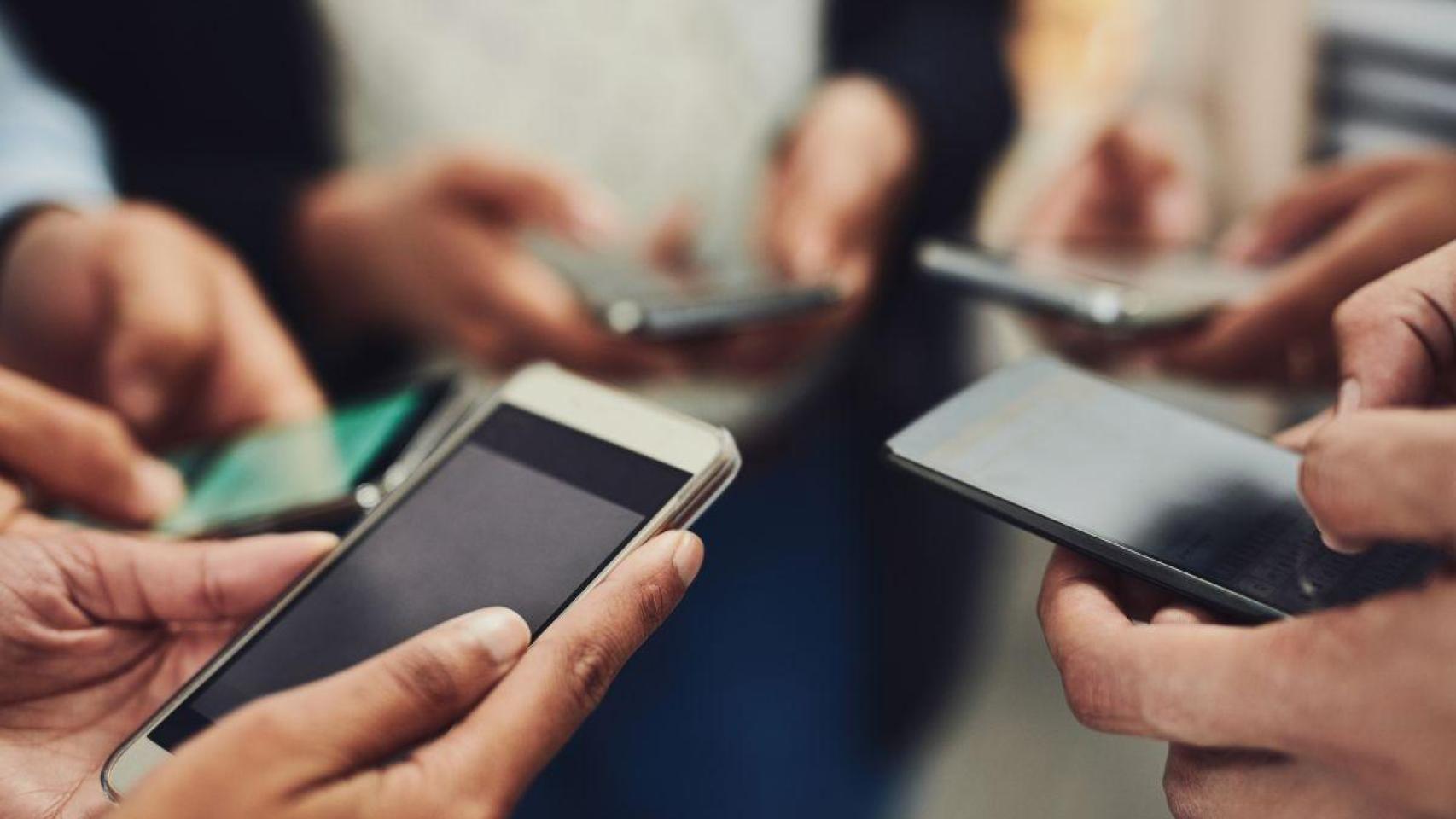 Adolescentes hacen uso del móvil