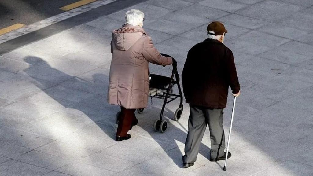 Dos personas mayores caminan.