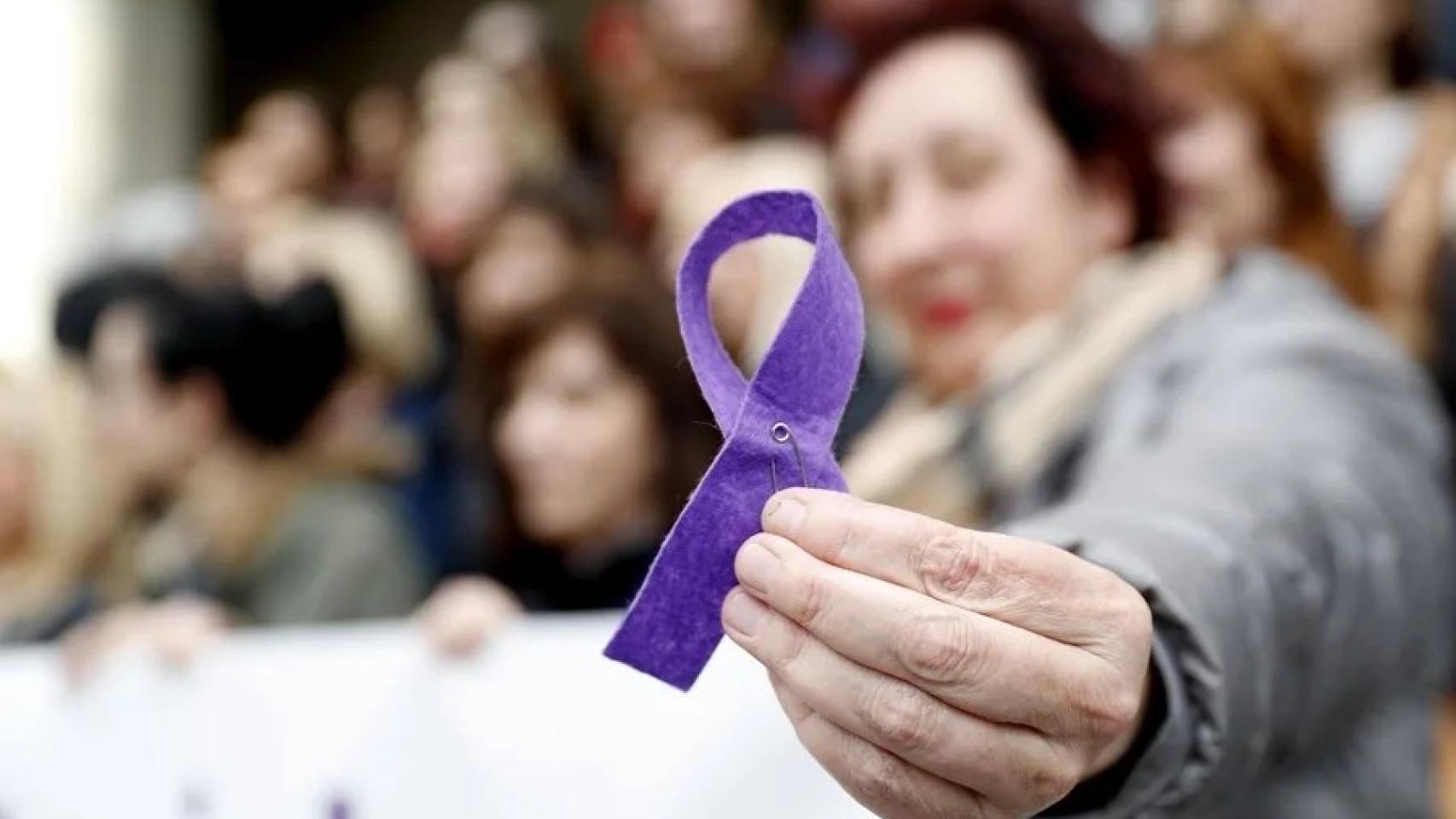Una mujer sostiene un lazo morado en una imagen de archivo