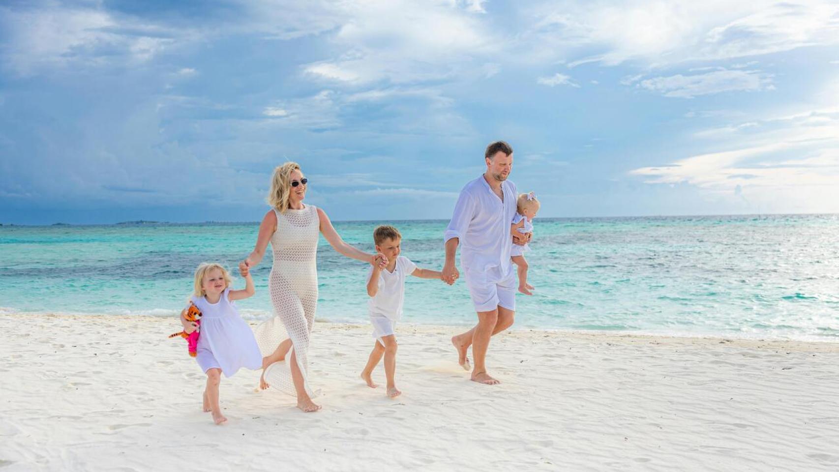 Familia pasea junto a la orilla del mar