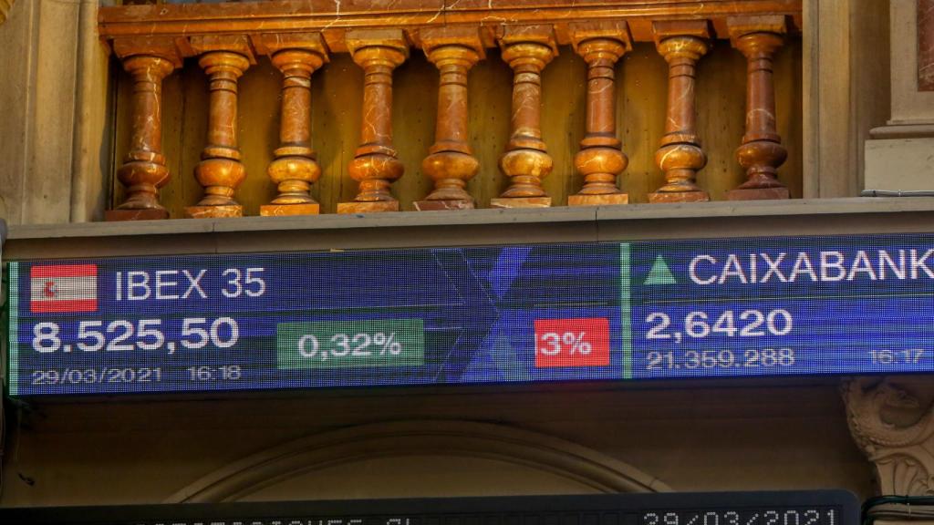 Pantallas de la Bolsa de Madrid, con las cotizaciones del Ibex 35 y Caixabank