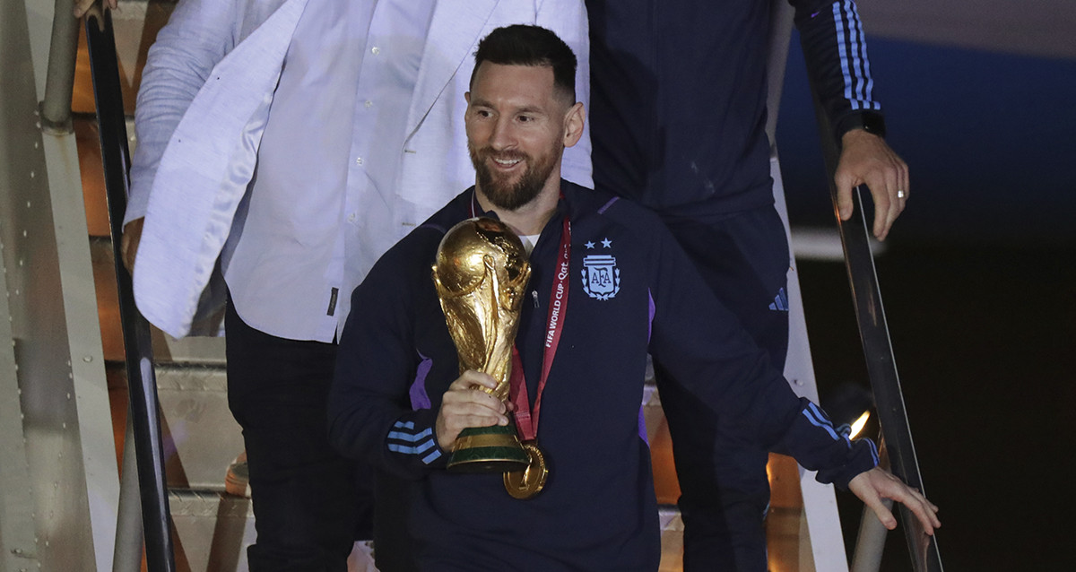 Lionel Messi, con la Copa del Mundo en sus manos, llegando a Argentina / EFE